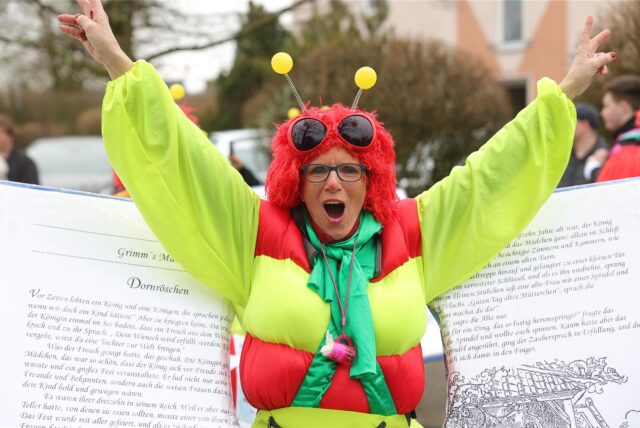 Eine Frau, die als Buchwurm verkleidet ist, beim Karnevalsumzug in Selm.