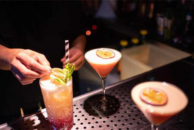 Ein Barkeeper bereitet Cocktails in einem Nachtclub zu.