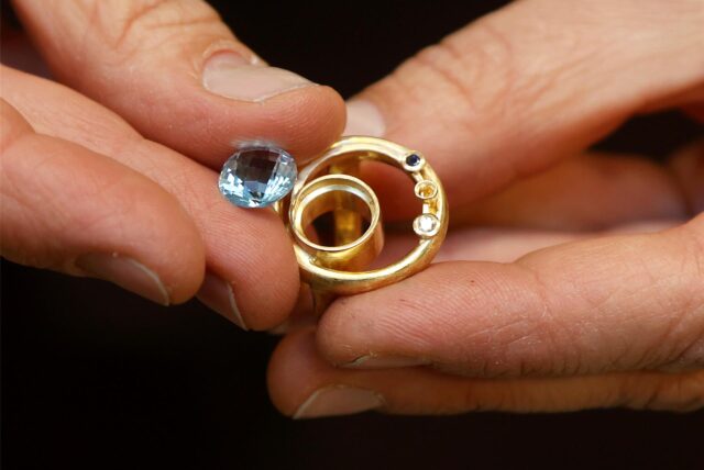Ein Schmuckstück, das sich in der Anfertigung befindet. Gold und Edelsteine müssen noch zusammen gesetzt werden.