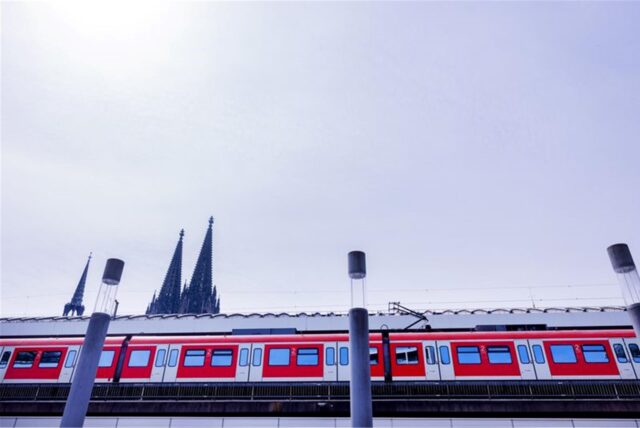 Eine Regionalbahn der Deutschen Bahn (DB) fährt vor der Kulisse des Kölner Doms in den Hauptbahnhof ein.