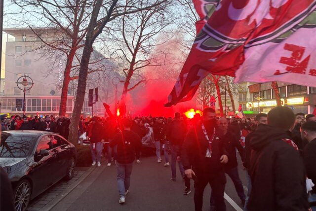 Lille-Fans zünden während des Fanmarsches in Dortmund Pyrotechnik.