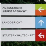 Blick auf ein Schild „Amtsgericht“, „Arbeitsgericht“, „Landgericht“ und „Staatsanwaltschaft“.