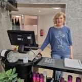 Die Inhaberin des neuen Friseursalons in Unna steht hinter der Kasse in ihrem Salon.