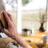 Eine ältere Person telefoniert mit einem Smartphone.