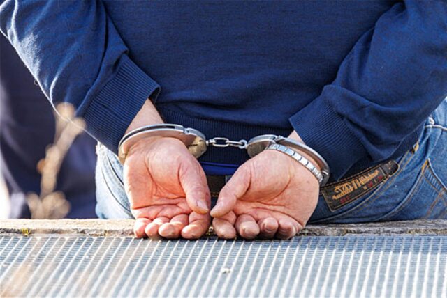 Ein Mann trägt Handschellen nach seiner Festnahme durch die Polizei.