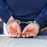 Ein Mann trägt Handschellen nach seiner Festnahme durch die Polizei.