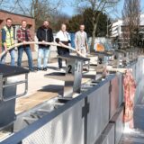 Daniel Lögering (Projektleiter), Dennis Junge, Jens Winiecki, Jens Holtsträter und Carsten Langstein (alle GSW) stemmen ein C-Rohr der Feuerwehr Kamen. Wasser fließt daraus in ein Schwimmbecken.