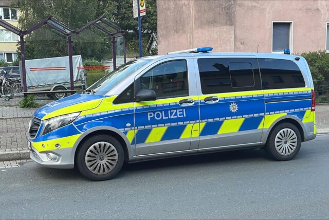 Ein Polizeiwagen steht an der Hochstraße in Bergkamen. Im Hintergrund sieht man Häuser und eine Bushaltestelle.