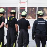 Feuerwehrleute mit Helm und T-Shirt bei einer Übung.