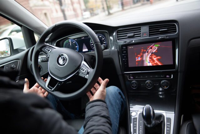 Ein Mann sitzt am Steuer eines VW.