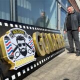 Osman Dahman aus Kamen steht neben einer Werbeschrift: Golden Barbershop. In Kamens Innenstadt wird