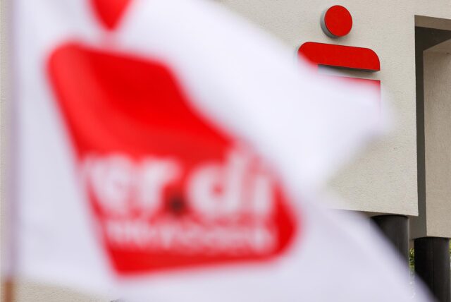 Eine Verdi-Fahne weht vor einer Sparkasse.