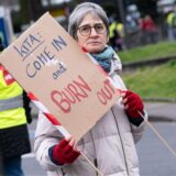 Bei einer Demonstration hält eine Person ein Schild mit der Aufschrift: Kita: Come in and burn out.
