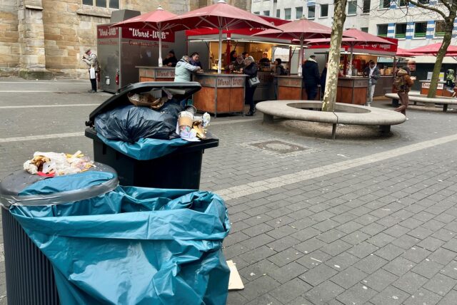 Vorne im Bild: Ein Müllsack, den das Team von Wurst Willi an einem bereits überquellenden Abfalleimer befestigt hat.