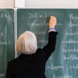 Eine Lehrerin schreibt mit Kreise auf eine Tafel.