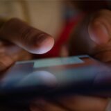 Ein Smartphone wird gehalten. In Dortmund ist kinderpornografisches Material auf dem Gerät eines Kindes aufgetaucht.