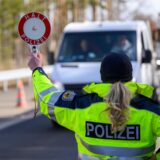 Eine Beamtin der Bundespolizei stoppt einen weißen Transporter.