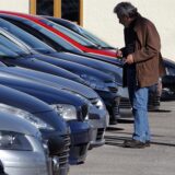 Ein Mann steht vor einer Reihe Autos.