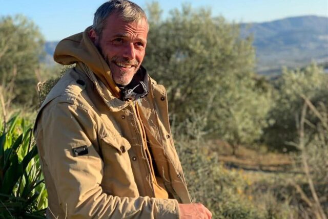 Christoph Tetzner sitzt am Rande eines Olivenhains auf Kreta in der Abendsonne.