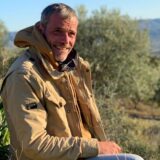 Christoph Tetzner sitzt am Rande eines Olivenhains auf Kreta in der Abendsonne.