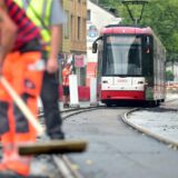 Arbeiter bei Gleisbauarbeiten auf der Linie U43 mit einer Bahn im Hintergrund.