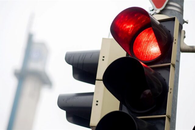 Eine rote Ampel leuchtet an einer Kreuzung im Stadtgebiet.