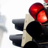 Eine rote Ampel leuchtet an einer Kreuzung im Stadtgebiet.