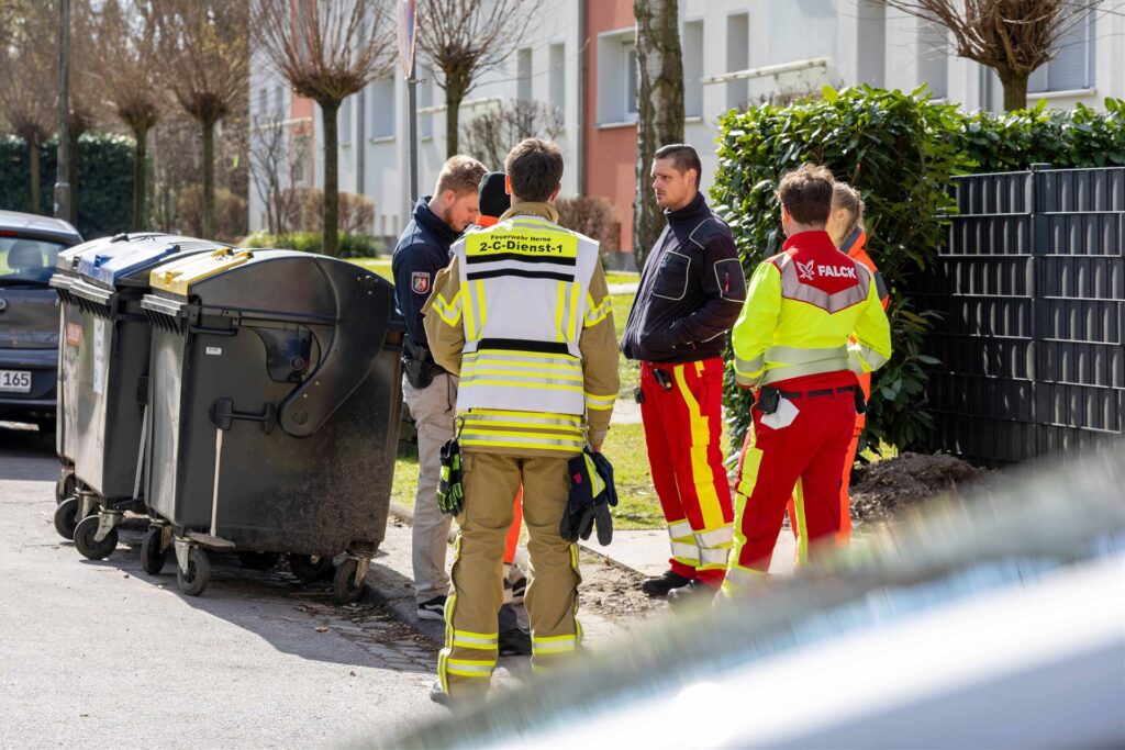 Einsatzkräfte in gelben Westen stehen an einer Straße. Einsatzkräfte in gelben Westen stehen an einer Straße.