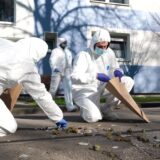 Mitarbeiter der Spurensicherung in ihrer Arbeitskleidung.