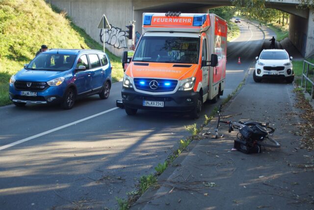 Die Straße „Am Langen Kamp“ in Kamen: Ein Rettungswagen und zwei Autos stehen an und auf der Straße, ein Fahrrad liegt am Wegesrand.