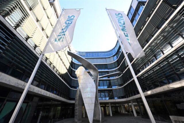 Fahnen mit der Aufschrift „Siemens“ wehen an der Siemens-Konzernzentrale an der Werner von Siemens Straße.