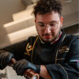 Mattia Nigro steht in der Küche und kocht.