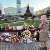 Eine Frau steht an einem Ort des Gedenkens für die Opfer einer Todesfahrt mit zwei Toten und mehreren Verletzten am Paradeplatz in der Innenstadt vor Blumen und Kerzen.