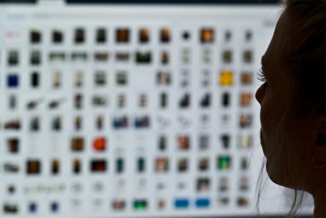 Frau sitzt vor mehreren Bildern auf einem Computerbildschirm