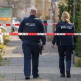 Eine Crimescene: Zwei Polizisten laufen durch einen abgesperrten Tatort.
