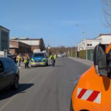 Eine Straße in einem Gewerbegebiet wird von Einsatzfahrzeugen abgesperrt.