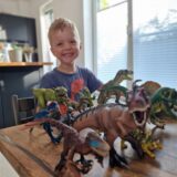 Phil (4) aus Dortmund sitzt vor Dinosaurier-Spielfiguren. Der Vierjährige hat jetzt eine Knochenmarktransplantation erhalten.