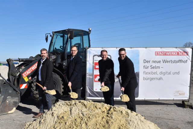 Christoph Lasek (Geschäftsführer Stadtwerke Selm GmbH), Markus Jungeilges ( Geschäftsführer Stadtwerke Selm GmbH), Thomas Orlowski (Bürgermeister der Stadt Selm) und Tobias Icke (REMONDIS) mit je einer Schaufel vor einem Sandhaufen.