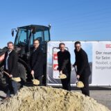 Christoph Lasek (Geschäftsführer Stadtwerke Selm GmbH), Markus Jungeilges ( Geschäftsführer Stadtwerke Selm GmbH), Thomas Orlowski (Bürgermeister der Stadt Selm) und Tobias Icke (REMONDIS) mit je einer Schaufel vor einem Sandhaufen.