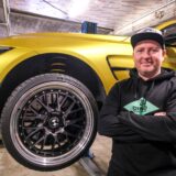 Ein Mann steht mit verschränkten Armen vor einem Sportwagen, der auf einer Hebebühne in einer Werkstatt in Recklinghausen steht.