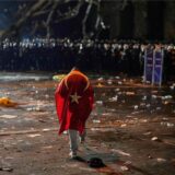 Ein Mann schwenkt eine Türkei-Fahne vor einer Reihe von Polizisten.