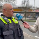 Ein Reporter spricht mit einem Polizeisprecher.