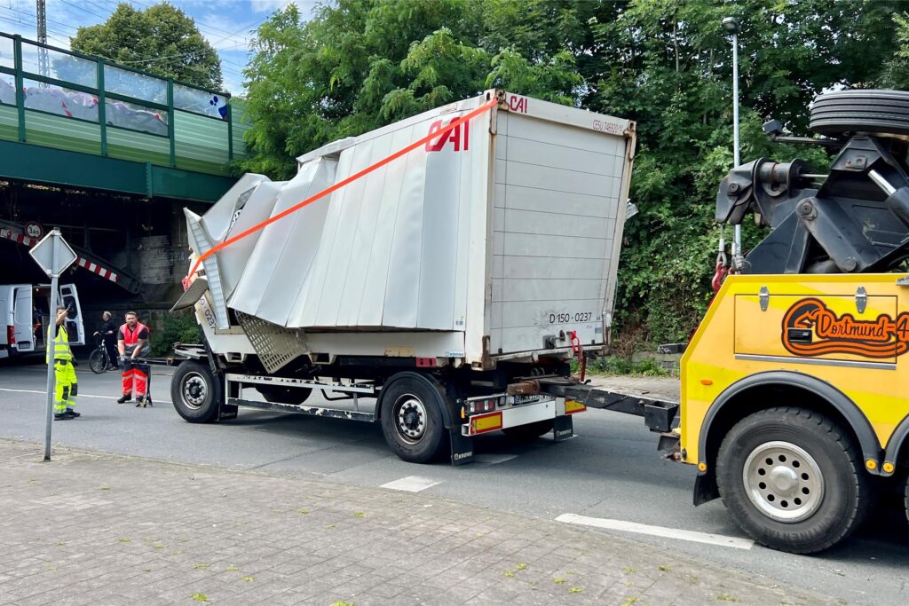 Ein beschädigter Lkw-Aufbau wird von einem Abschleppwagen abgeschleppt Ein beschädigter Lkw-Aufbau wird von einem Abschleppwagen abgeschleppt