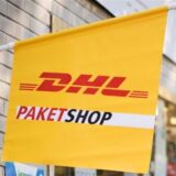 Eine Fahne weist auf einen DHL-Paketshop hin.