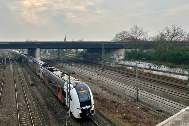 Ein RRX-Zug fährt unter einer A45-Brücke in Dortmund hindurch.
