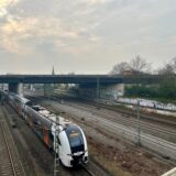 Ein RRX-Zug fährt unter einer A45-Brücke in Dortmund hindurch.