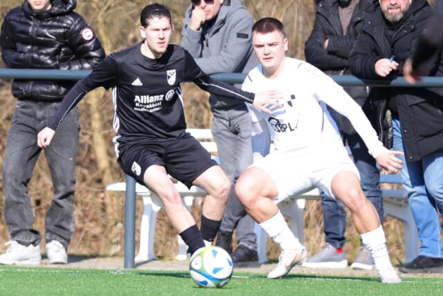 Zwei Spieler kämpfen in der Luft um den Ball.