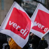 Beschäftigte demonstrieren mit Verdi-Fahnen.