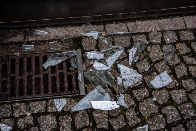Glasscherben liegen auf einem gepflasterten Weg.