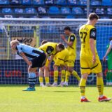 Die Spieler der BVB-U23 beugen sich enttäuscht Richtung Rasen.